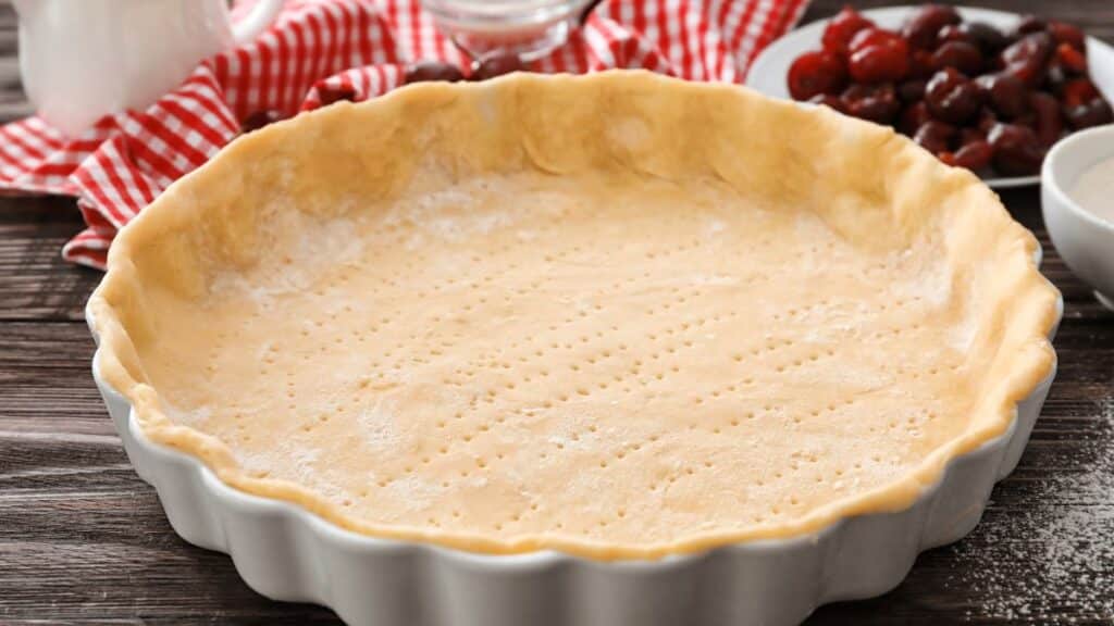 Pâte à tarte dans un moule blanc.